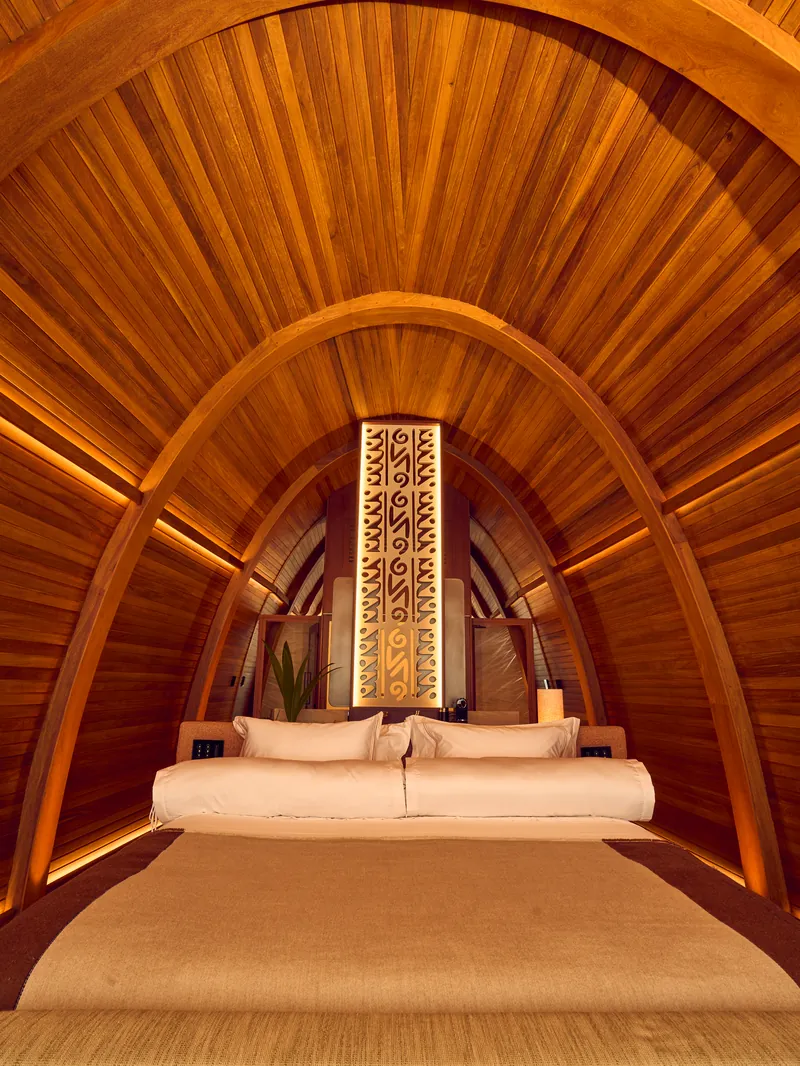 Quarto sob a abóbada de madeira, com a cama ao fundo