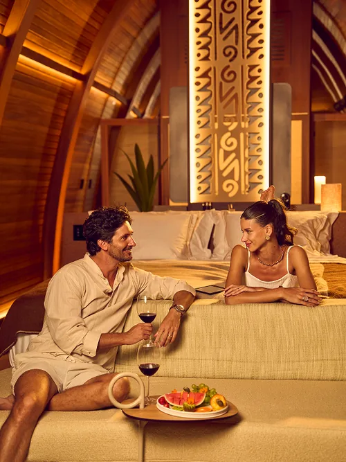 Casal brindando no quarto de uma acomodação Nanö